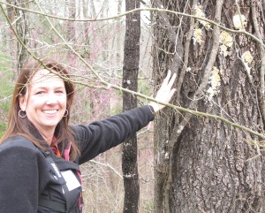 Joanna Weitzel, Executive Director of Camp Discovery, explains to a nature class how suet is smeared on a tree to feed birds in the winter.