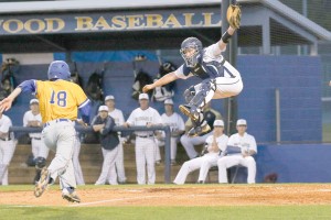 Blythewood catcher Andrew Crook makes a leaping grab of the throw in to the plate as Lexington’s Dalton Lansdowne heads for home. (Photo/Melissa Cooper)