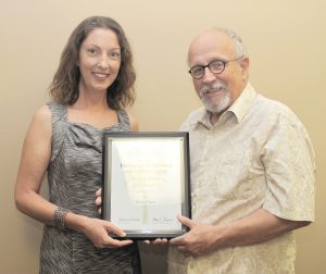 Bill Rogers, Executive Director of the S.C. Press Association (right) presents Voice graphic designer Ashley Ghere with her fifth consecutive Best in Show PALMY Award for ad design.