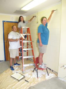 Volunteer painters Jeff and Allison Spires and Rhetta Taylor put the finishing touches on a classroom at Richard Winn Academy. (Photo/Barbara Ball)
