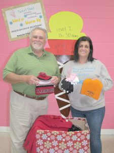 Blythewood Mayor J. Michael Ross and Susan DeMarco, owner of Sweet Pea’s Ice Cream in Blythewood, display some of the warm weather jackets, hats and gloves that have been donated for homeless people in the community. (Photo/Barbara Ball)